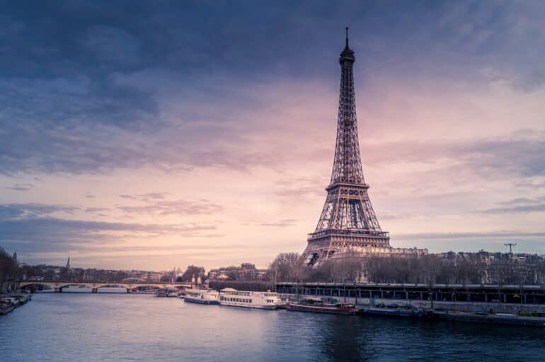 beautiful wide shot eiffel tower paris surrounded by water with ships colorful sky