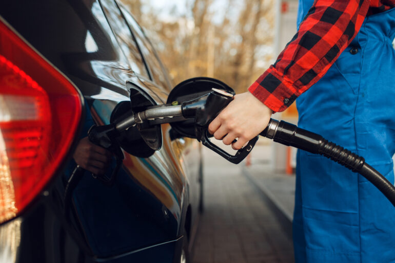 Operatore fa rifornimento a un’auto diesel in una stazione di servizio, simbolo del dibattito sul blocco auto diesel Euro 5 rinviato al 2026.