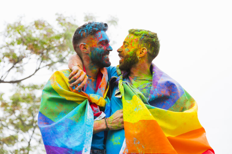 gay couple with painted faces rejoicing hugging